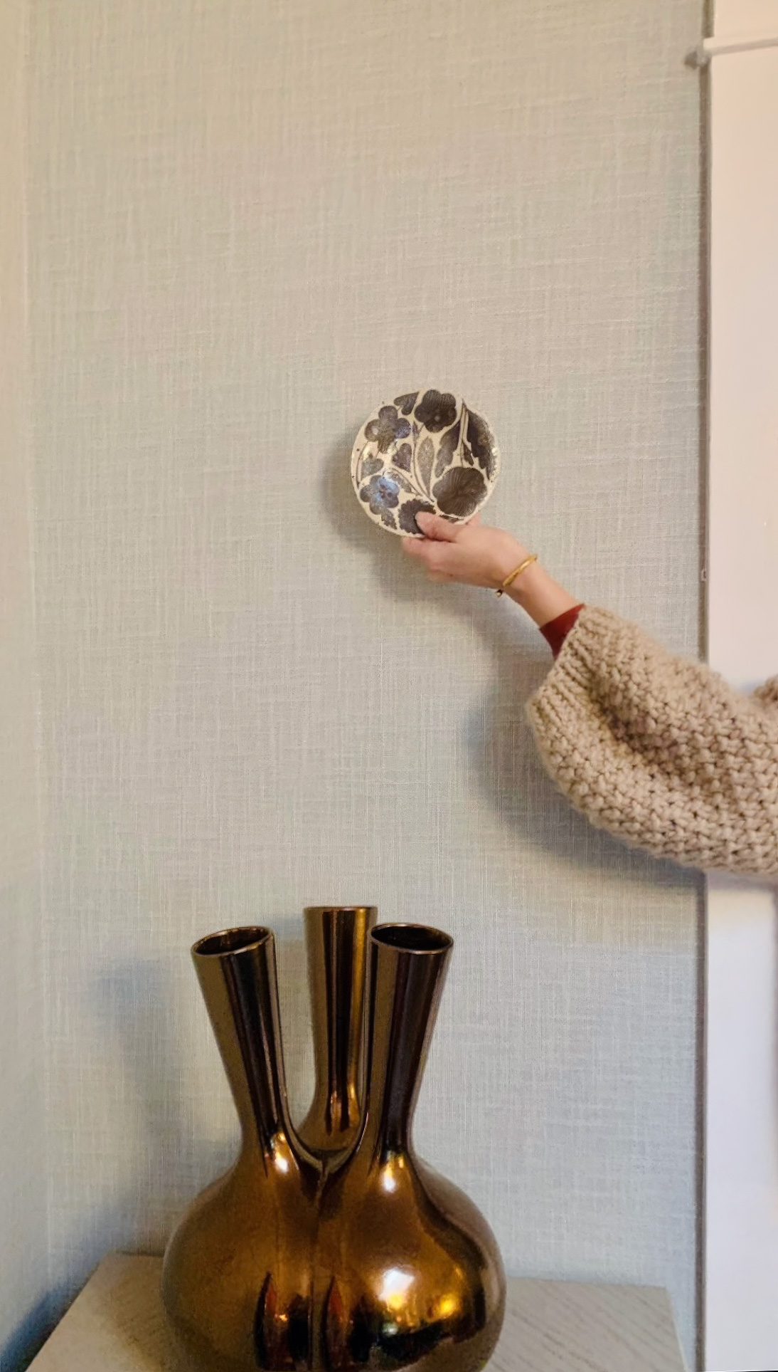 Hanging art with Kim Colwell on Phillip Jeffry's wallpaper, above Mama Vase by Roderick Vos. 